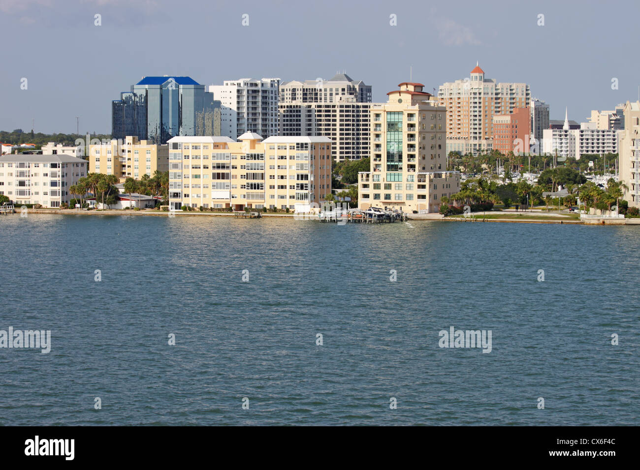 Voir des bâtiments sur le bord de la baie de Sarasota, Sarasota, Floride à partir de l'eau avec palmiers et un ciel bleu. Banque D'Images