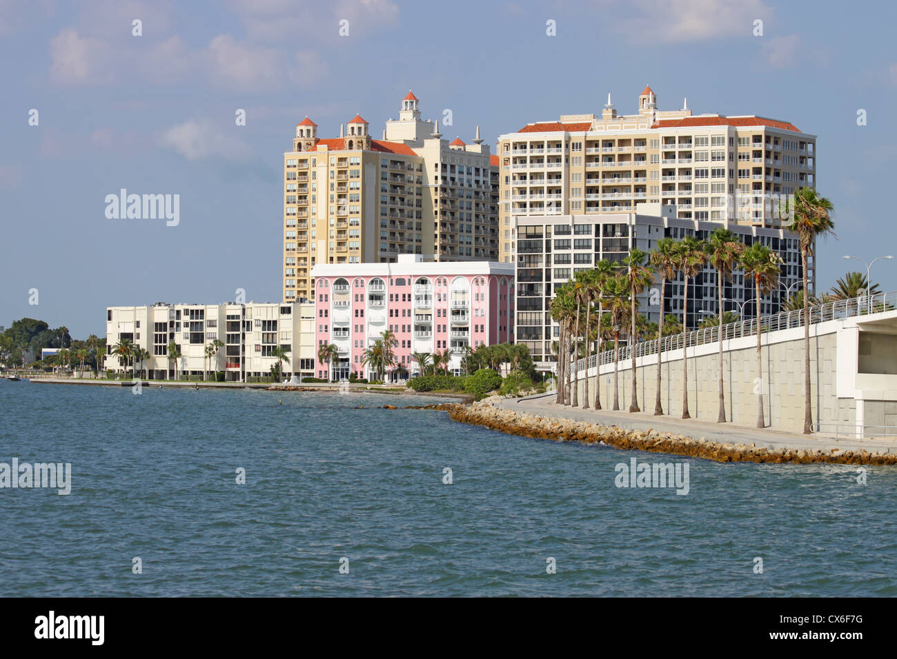 Voir des bâtiments sur le bord de la baie de Sarasota, Sarasota, Floride à partir de l'eau avec palmiers, ciel bleu et nuages. Banque D'Images