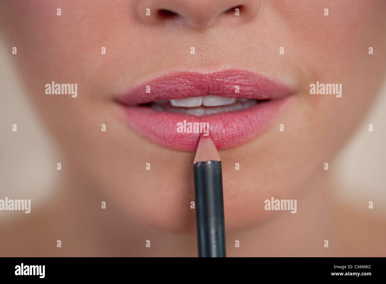 Une jeune femme l'application de recouvrement de lèvre, montrant la partie inférieure de la face Banque D'Images