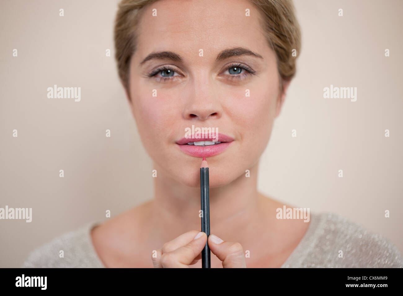 Une jeune femme l'application de recouvrement de lèvre Banque D'Images