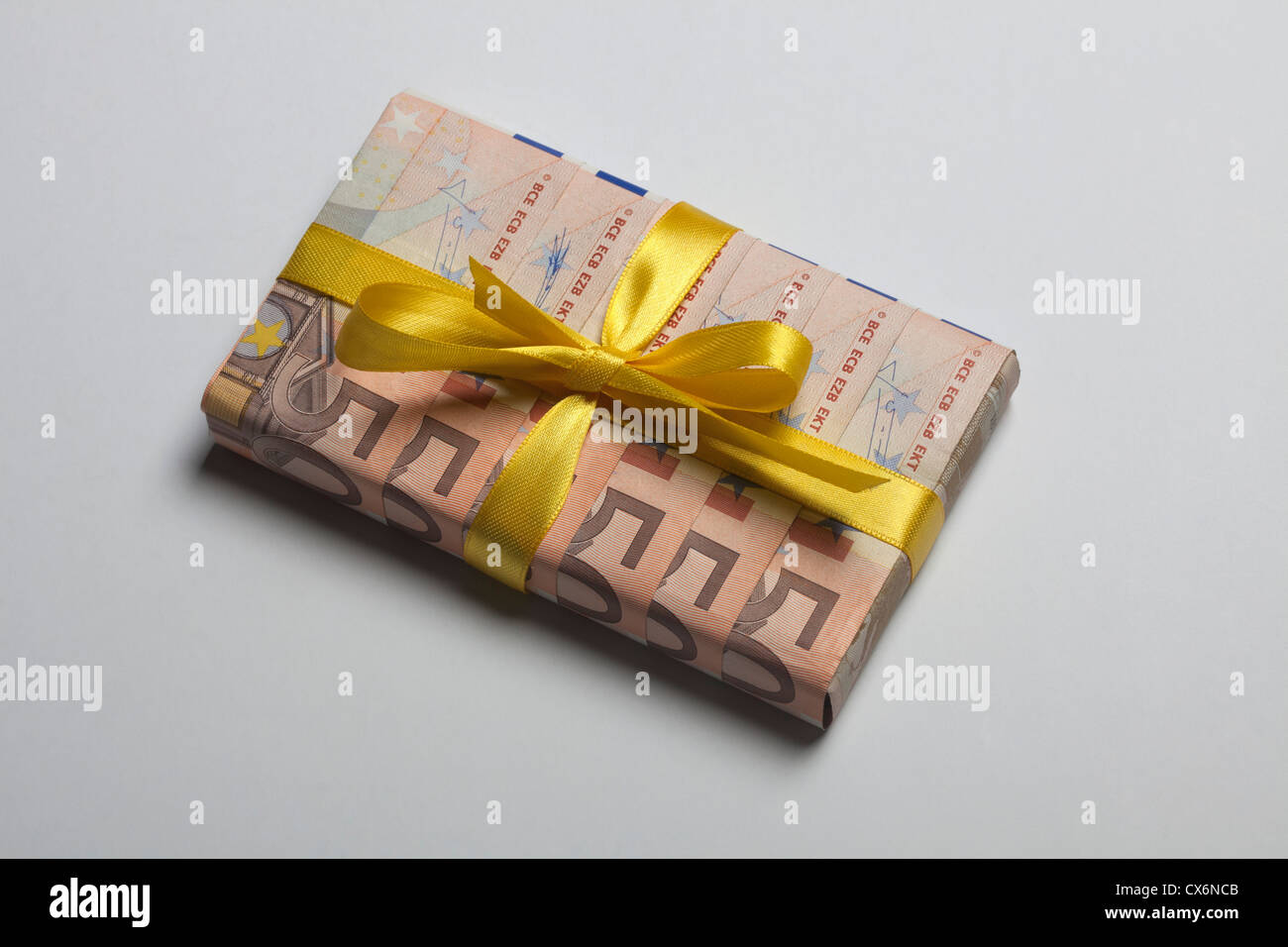 Cinquante billets utilisé pour emballer un cadeau avec un arc jaune Banque D'Images