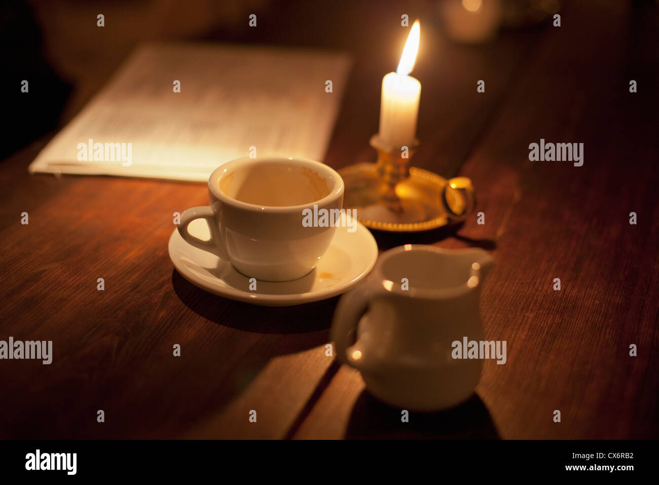 Tasse de café vide par la lumière de bougie Banque D'Images