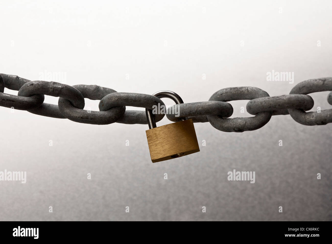 Une chaîne en acier connecté avec un cadenas d'or Banque D'Images