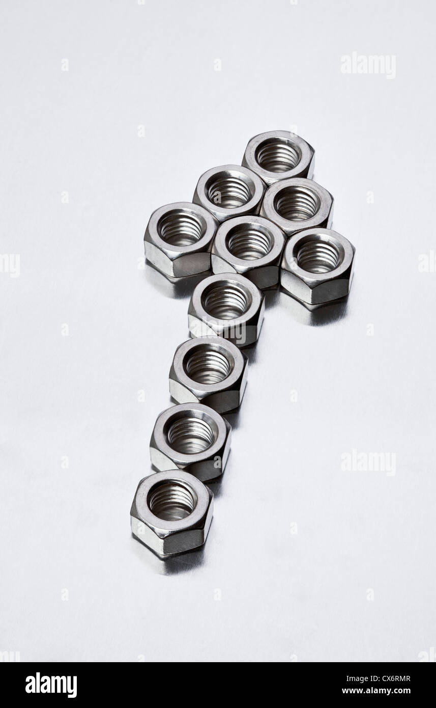 Les écrous métalliques disposées en forme d'une flèche sign Banque D'Images