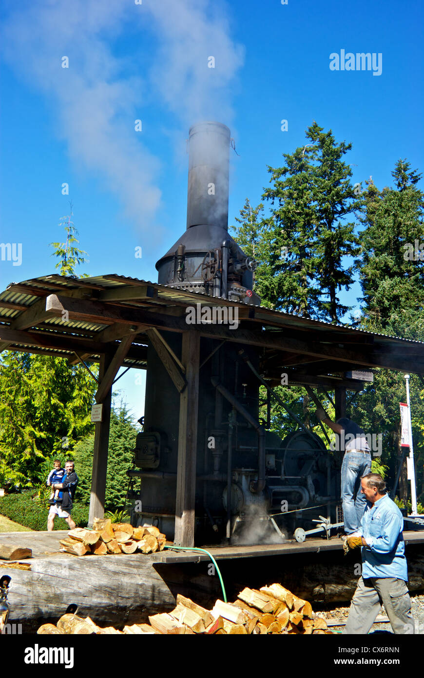 Spectateurs regardant des mécaniciens travaillant sur feu de bois restauré âne vapeur affichage moteur Musée de Campbell River Banque D'Images