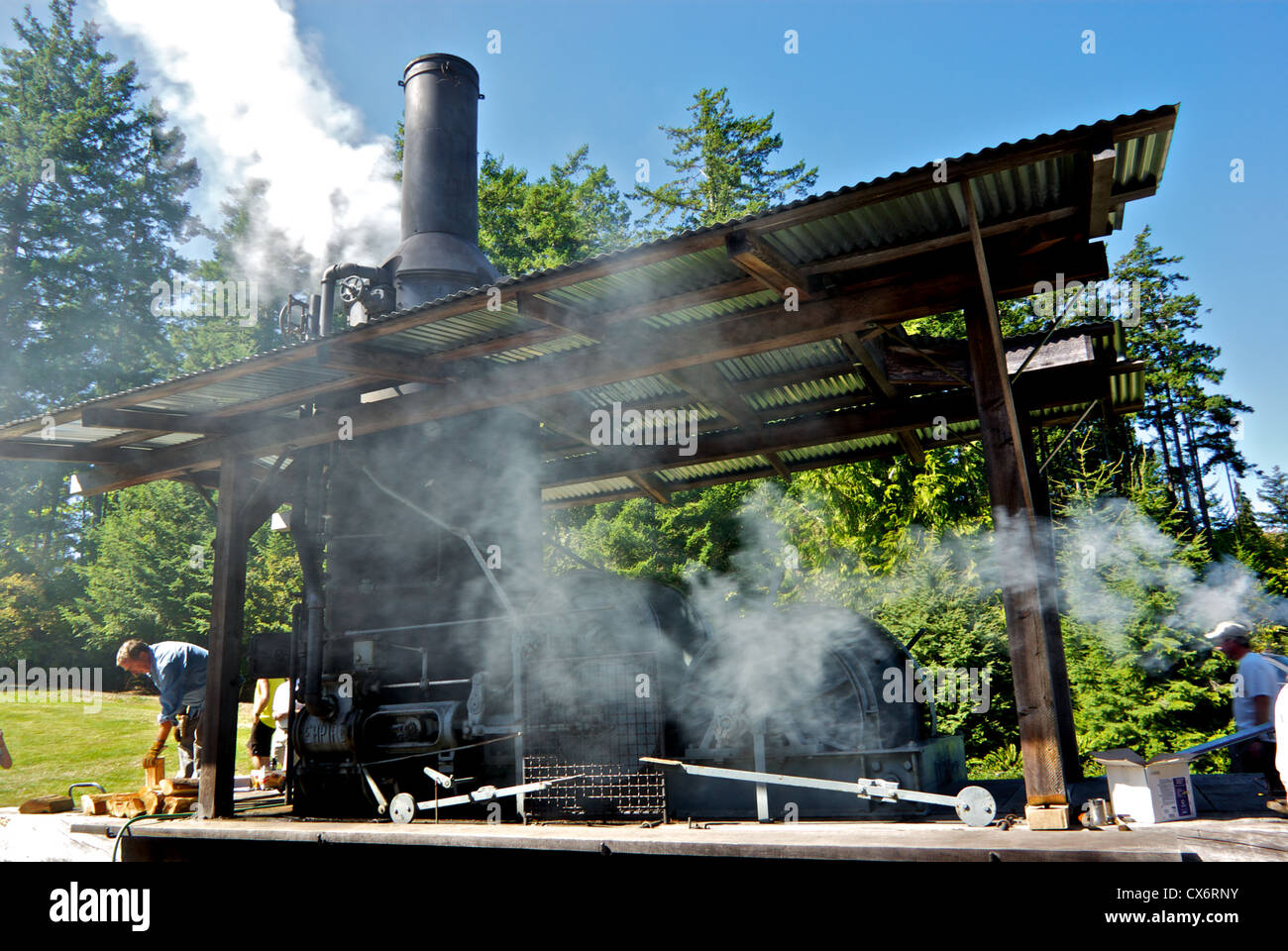 Des ingénieurs qui travaillent à vapeur alimentées au bois restauré fumée moteur âne un affichage en extérieur Musée de Campbell River BC Canada Banque D'Images