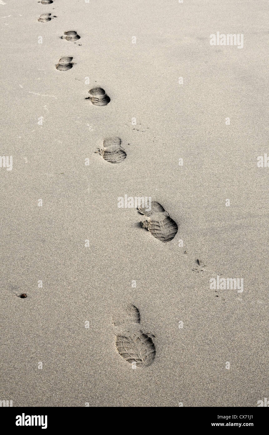 Concept de l'activité humaine -voie solitaire des empreintes de pas dans le sable humide. Se concentrer davantage sur la zone autour de 2D & 3ème empreinte écologique. Métaphore Tracker Banque D'Images