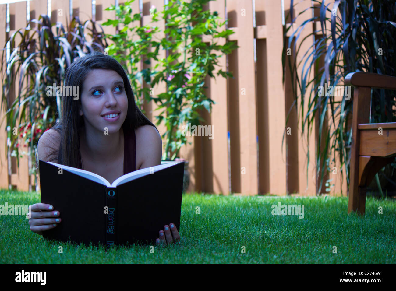 Jolie teen girl reading à l'extérieur - copyspace Banque D'Images