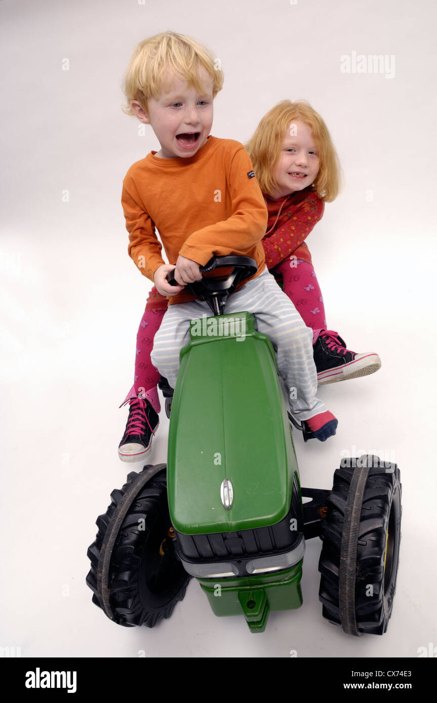 Deux enfants sur tracteur Jouet Banque D'Images