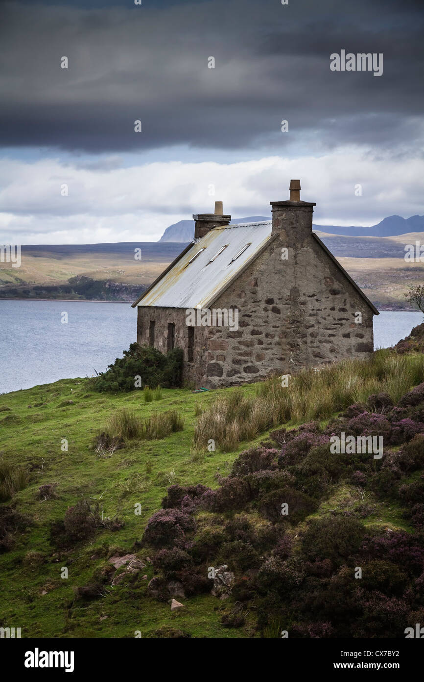 Sous un ciel orageux Crofters cottage avec vue sur le Loch Torridon Wester Ross ouest des Highlands en Écosse Banque D'Images