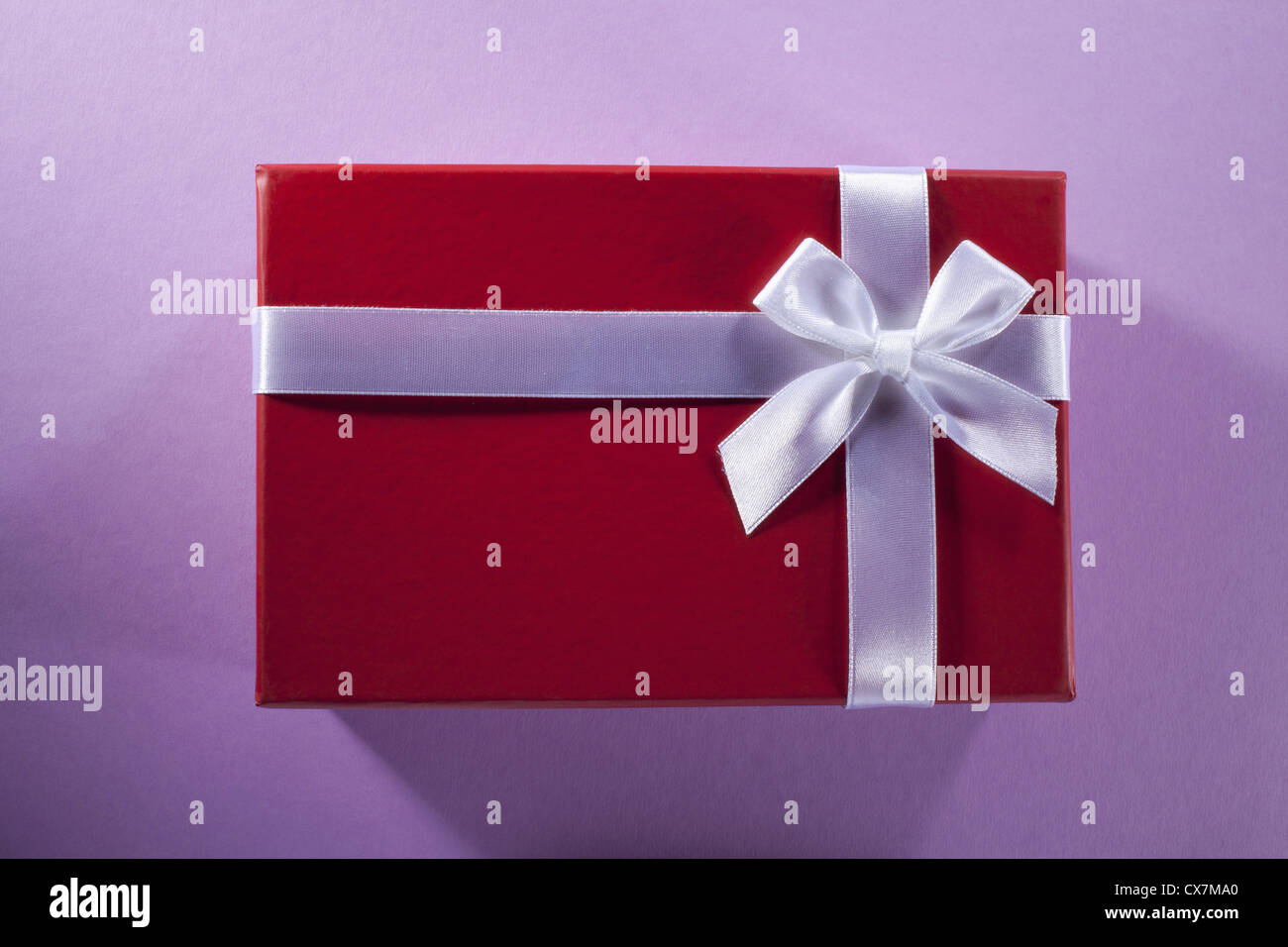 Un cadeau enveloppé dans du papier rouge et blanche et bow Banque D'Images