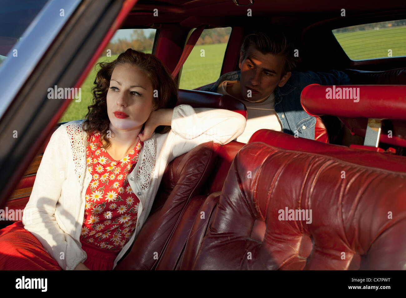 Une femme rockabilly et homme assis dans une voiture ancienne Banque D'Images
