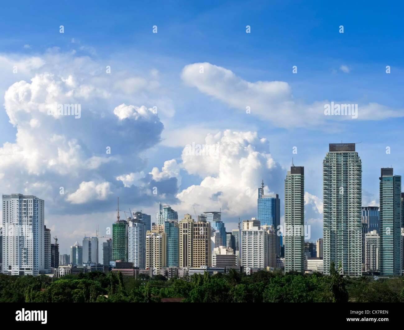 Skyline de Makati tourné contre le ciel bleu et nuages tourbillonnant Banque D'Images