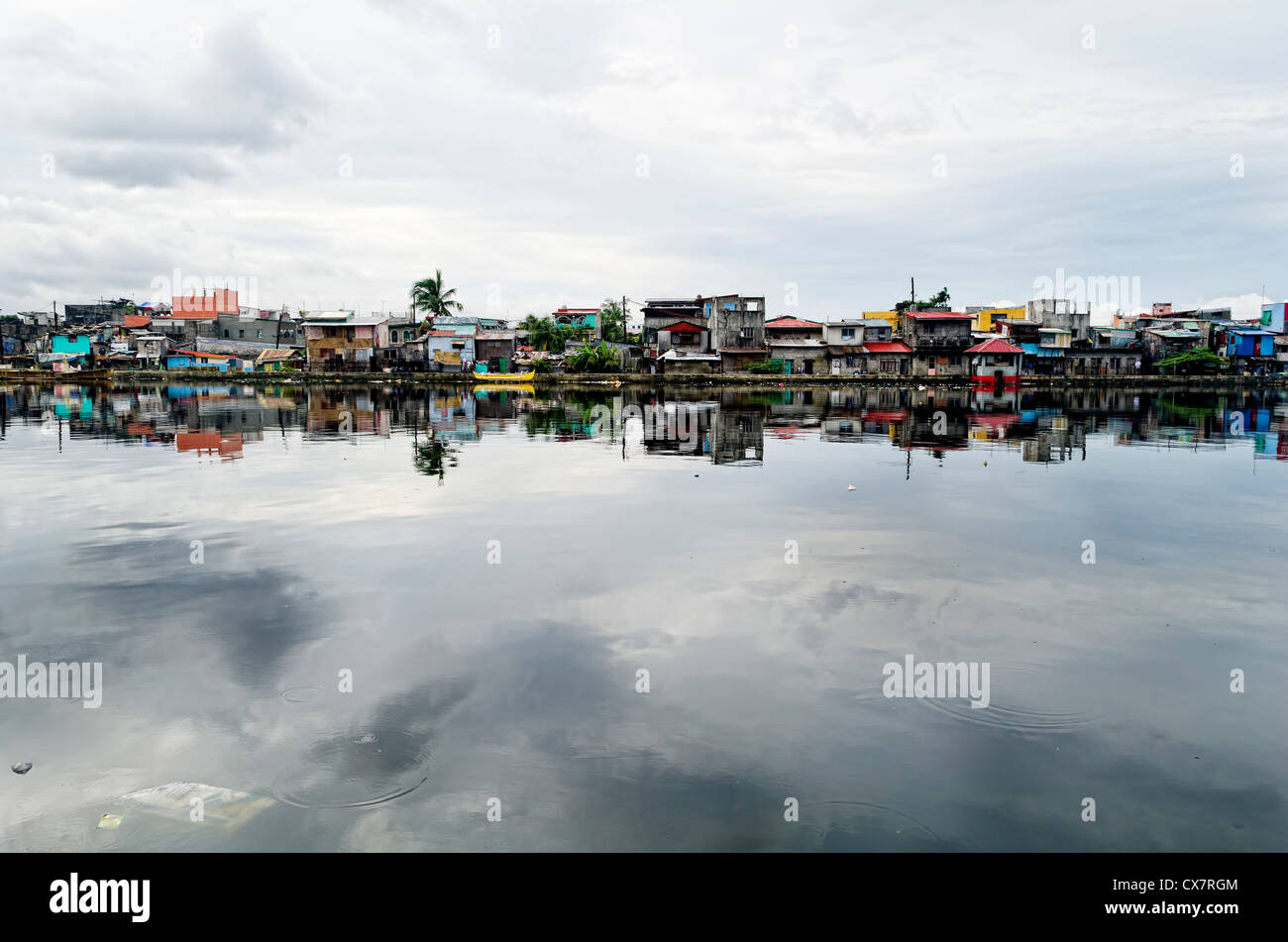 Rangées de maisons le long de la rivière Malabon dans la métro Manille, Philippines Banque D'Images