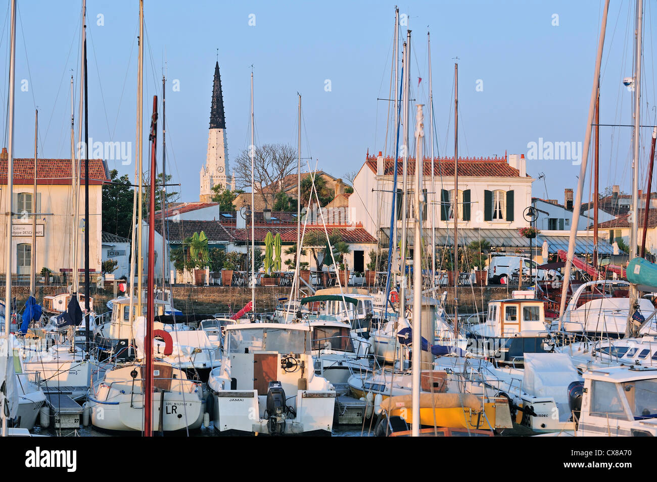 Le noir et blanc tour de l'église et la voile bateaux du port, à Ars-en-Ré sur l'île Ile de Ré, Charente-Maritime, France Banque D'Images