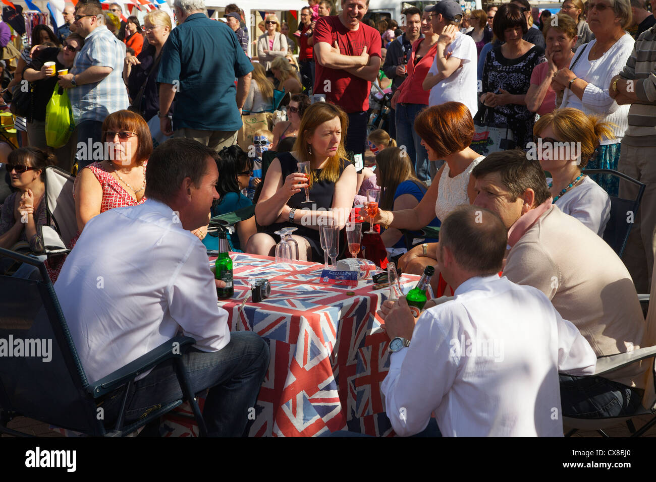 Les gens sur une Union Jack table à Carlisle célébrations jubilaires dans le centre-ville de Carlisle Cumbria, Angleterre, Royaume-Uni Banque D'Images