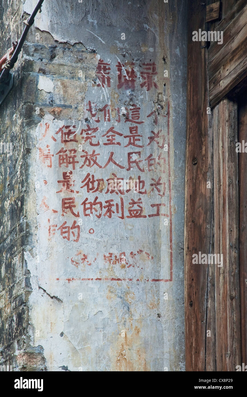 Les mots du président Mao écrit sur les murs dans une ville ancienne près de Guilin dans la région autonome Zhuang du Guangxi Banque D'Images