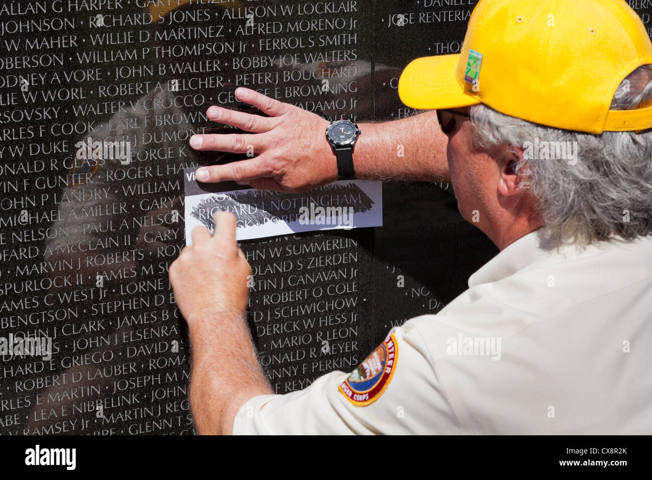 Un vétéran de frottement de crayon d'un nom à la guerre du Vietnam Memorial - Washington, DC USA Banque D'Images