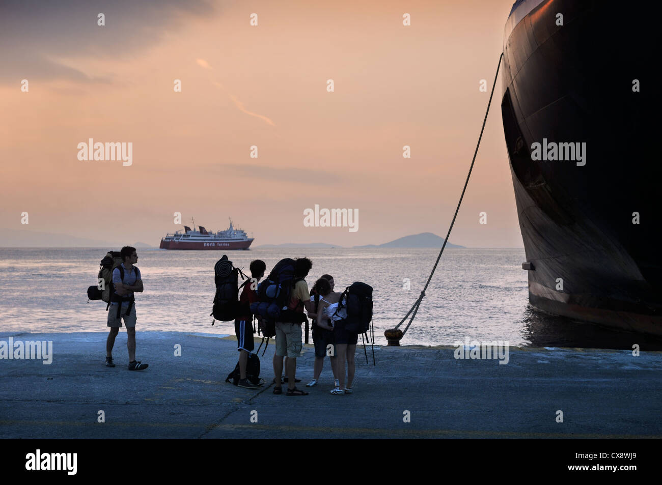 Randonneurs sur le quai à Aegina avec des ferries en partance pour le port du Pirée à Athènes, Grèce Banque D'Images