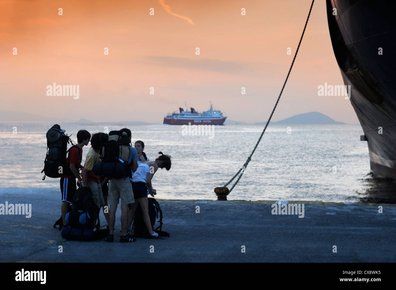 Randonneurs sur le quai à Aegina avec des ferries en partance pour le port du Pirée à Athènes, Grèce Banque D'Images
