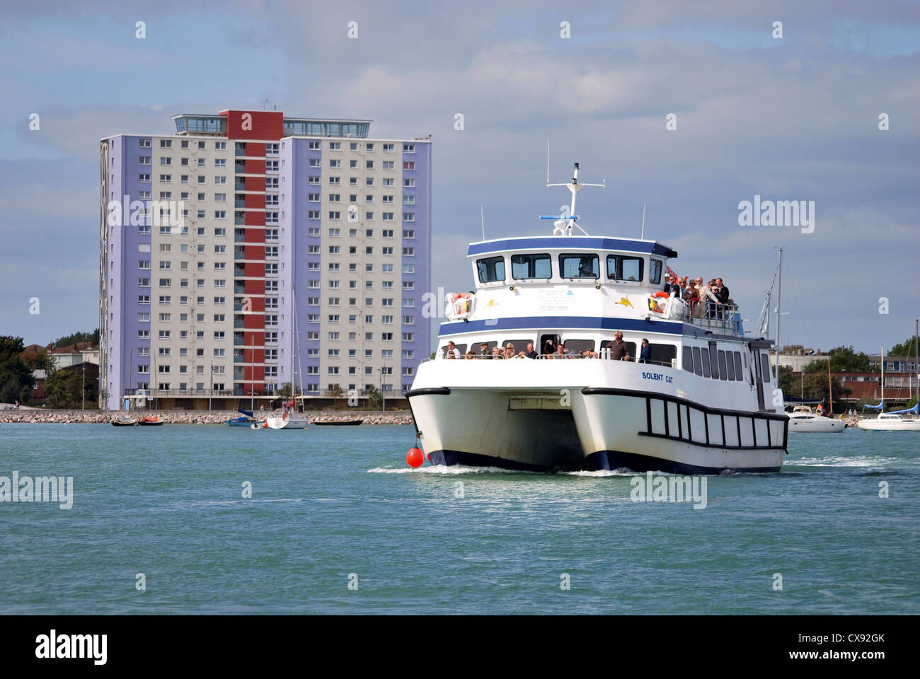 Un bateau d'excursion avec un bon nombre de passagers dans le port de Portsmouth avec Gosport derrière elle. Banque D'Images