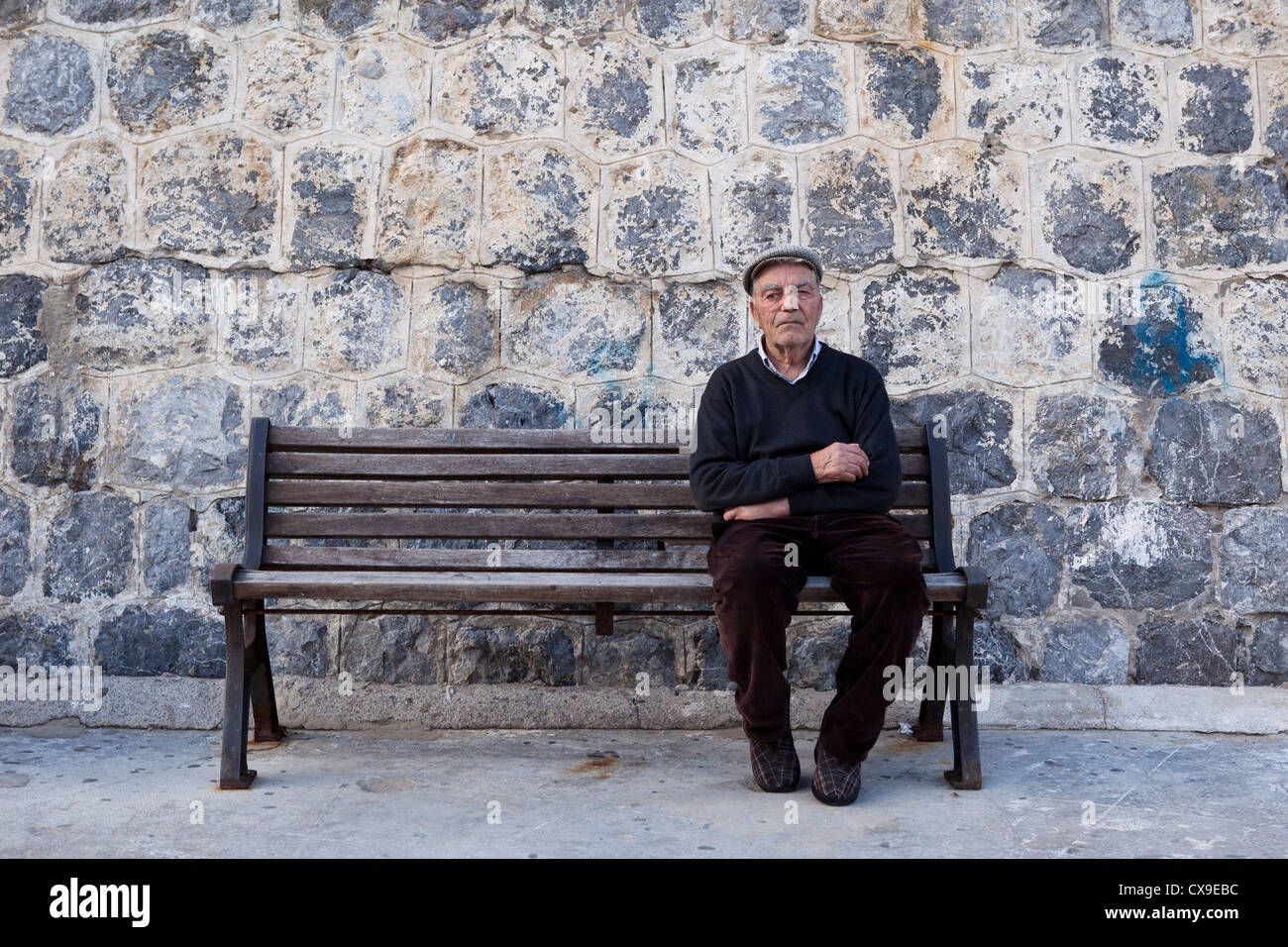 Vieil homme assis sur le banc en bois, Cefalu, Italie Banque D'Images