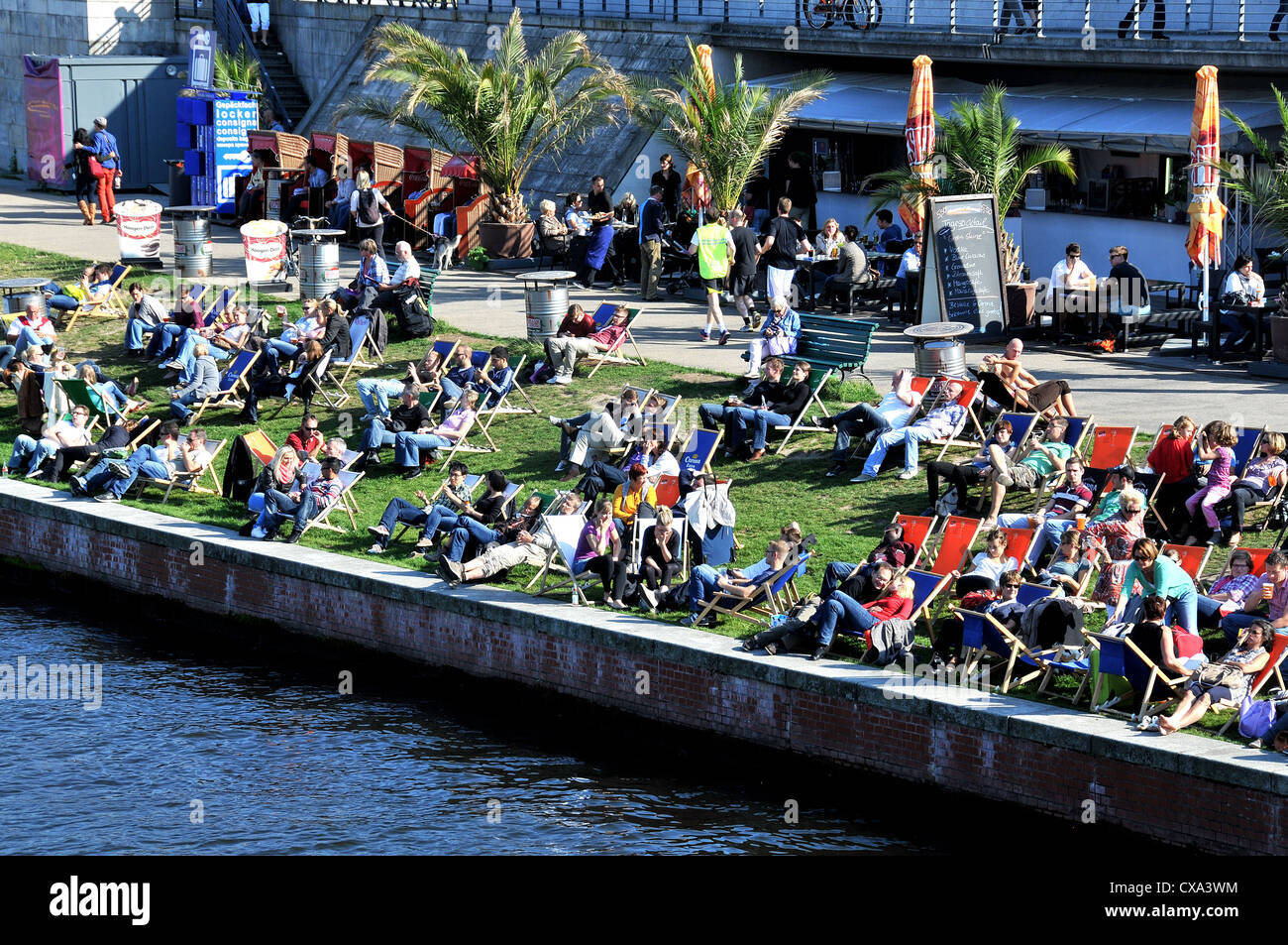 Les berlinois se détendre sur la banque de rivière Spree Berlin Allemagne Banque D'Images