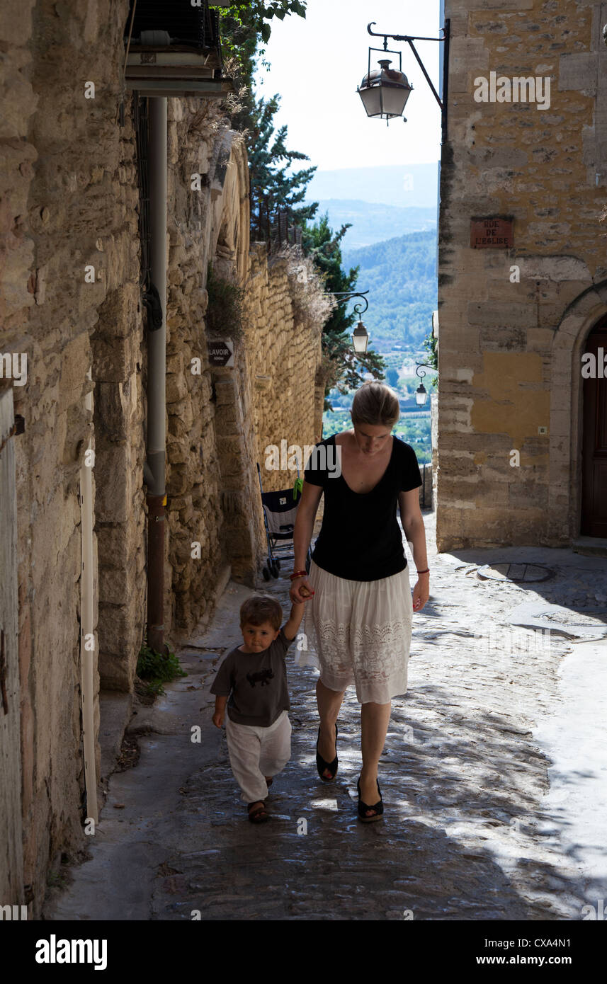 Femme et enfant marche à travers le village perché de Gordes, Luberon, Provence, France Banque D'Images