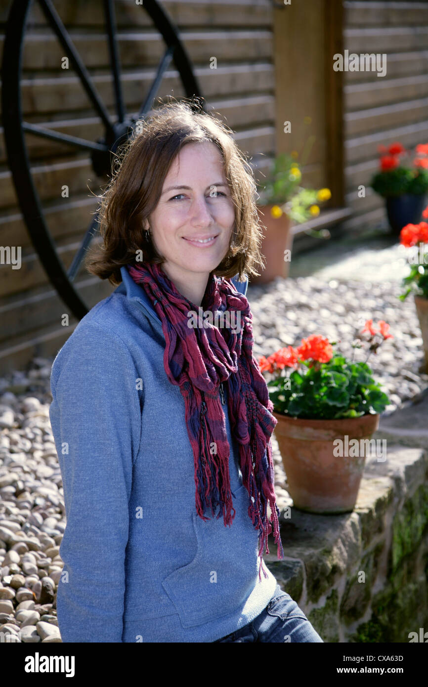 Jeune femme assise sur un mur Banque D'Images