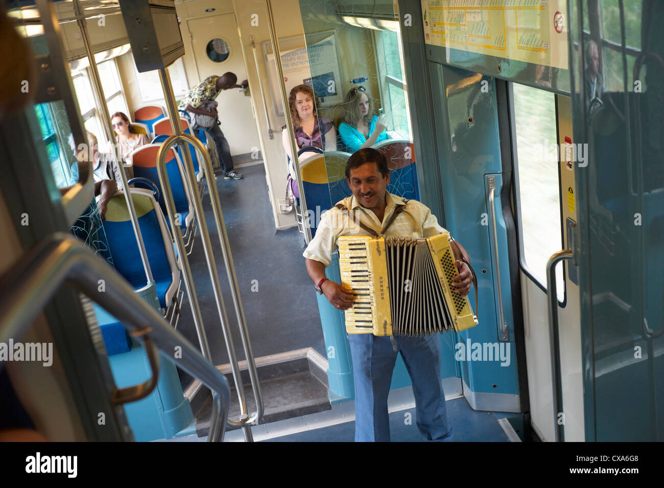 Un homme rom ou tsigane de la rue dans un train entre Paris et Versailles avec un accordéon Banque D'Images