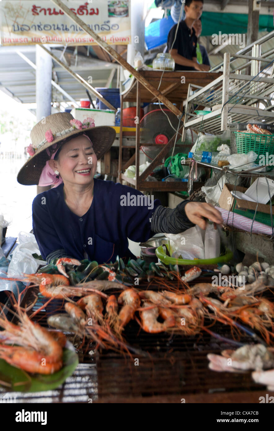 Torréfaction femme poisson frais au marché flottant à Bangkok, Thaïlande Banque D'Images