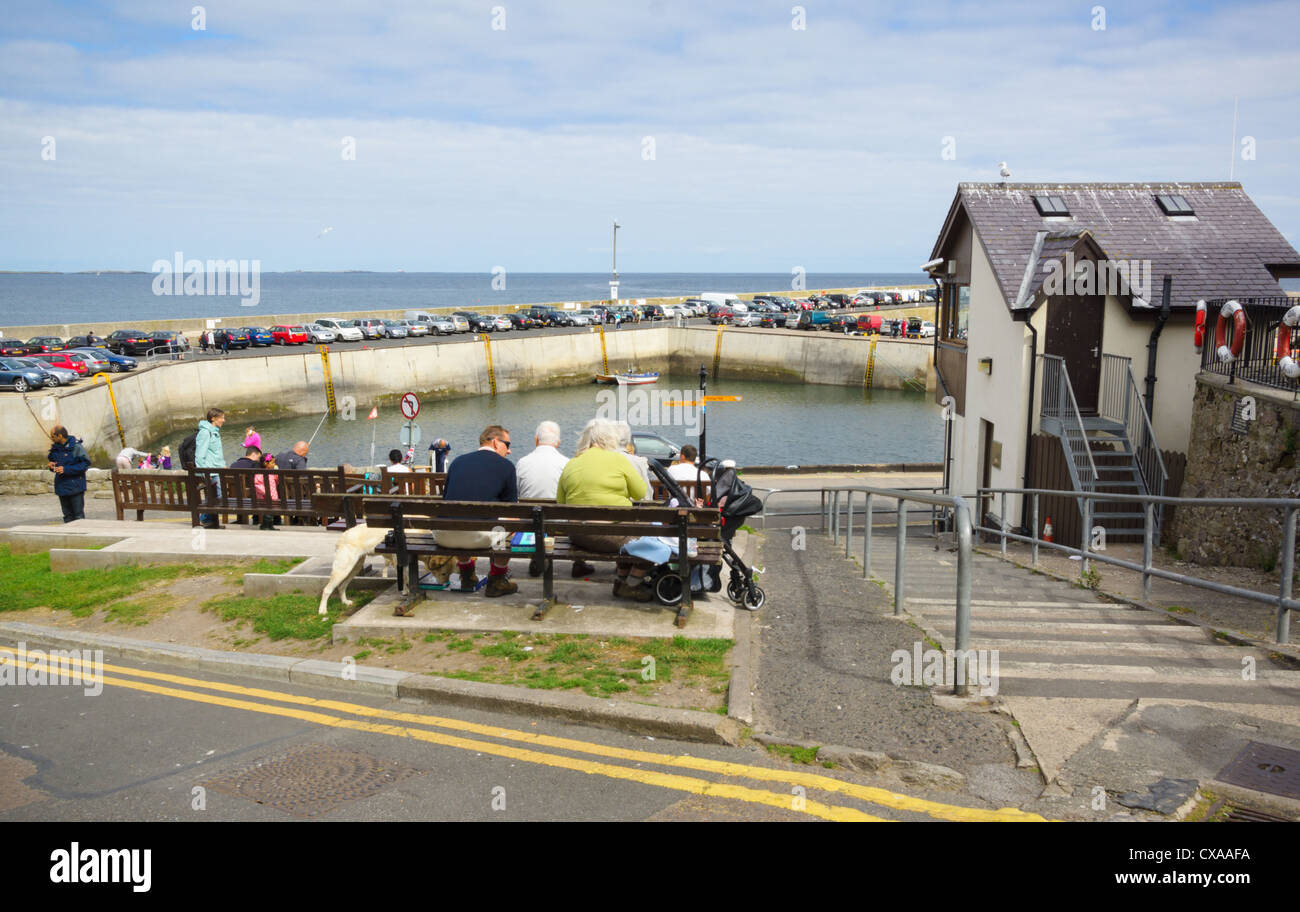Les touristes de prendre le temps de repos et regardez vers la mer dans le petit village côtier de Largs, dans le Northumberland. Banque D'Images