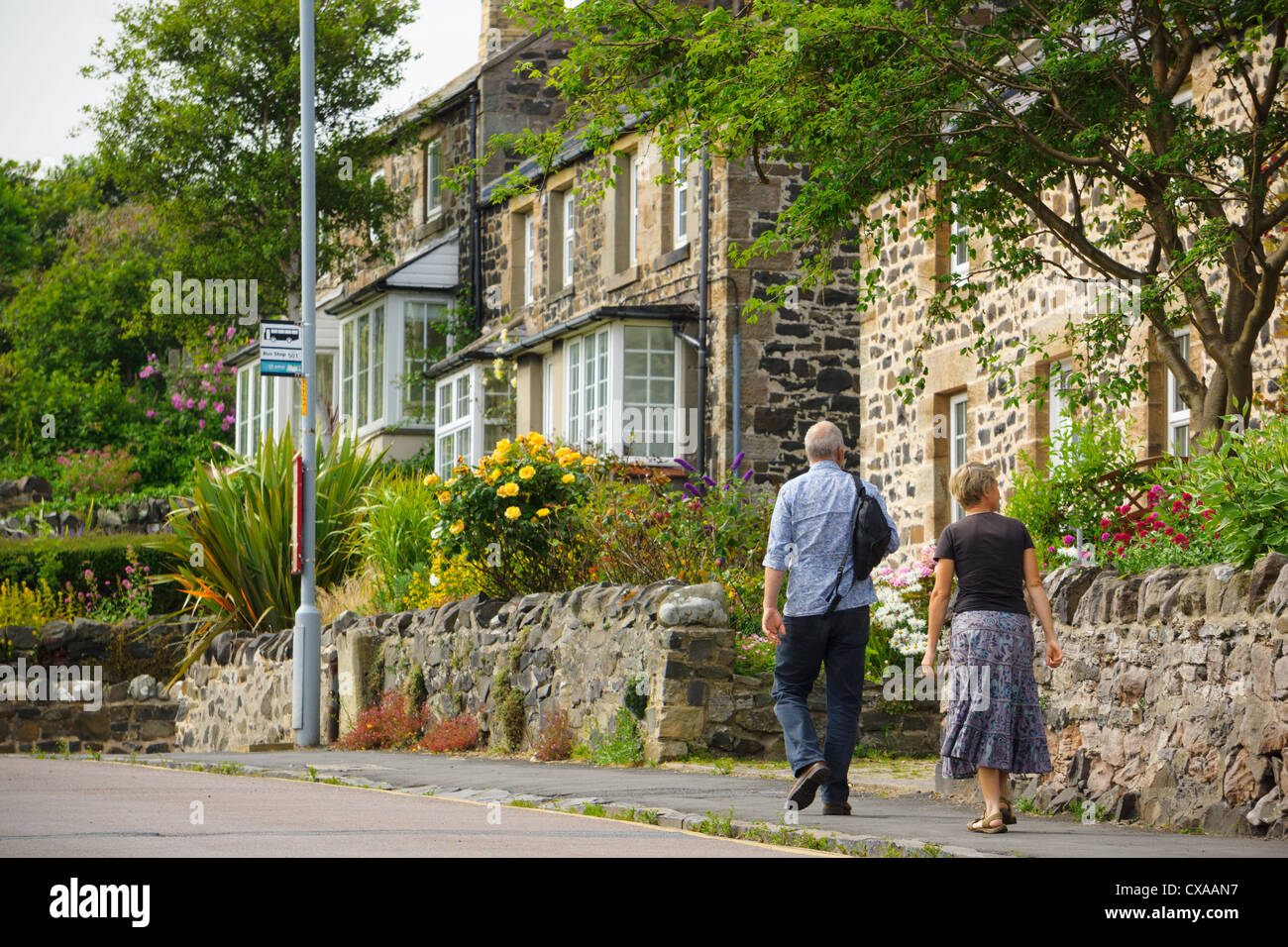 Un couple marchant dans une rue paisible à Craster, un village de pêcheurs dans le Northumberland Royaume-uni. Banque D'Images