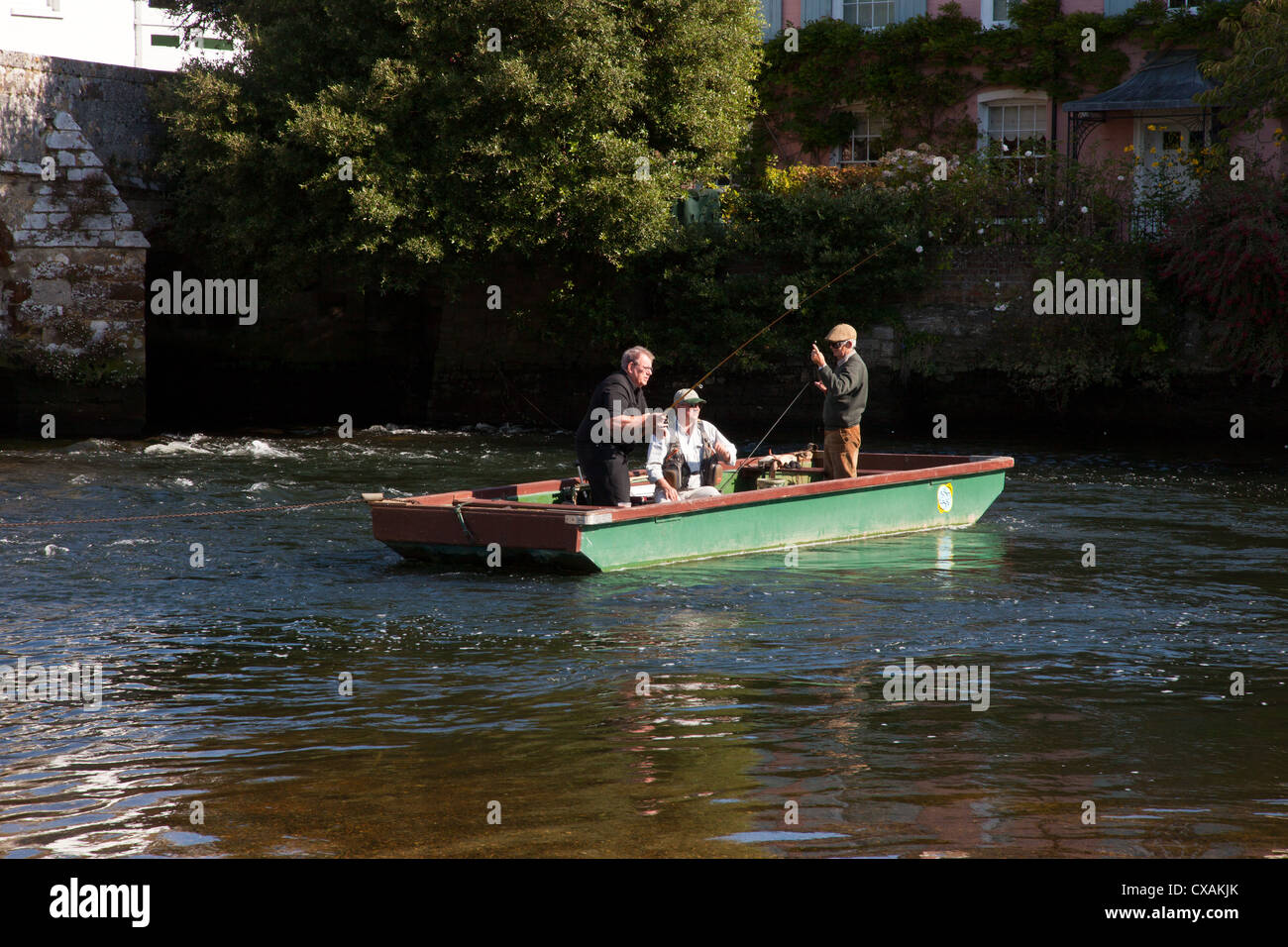 Trois hommes dans un bateau de pêche sur la rivière Avon à Christchurch Dorset England UK. Banque D'Images
