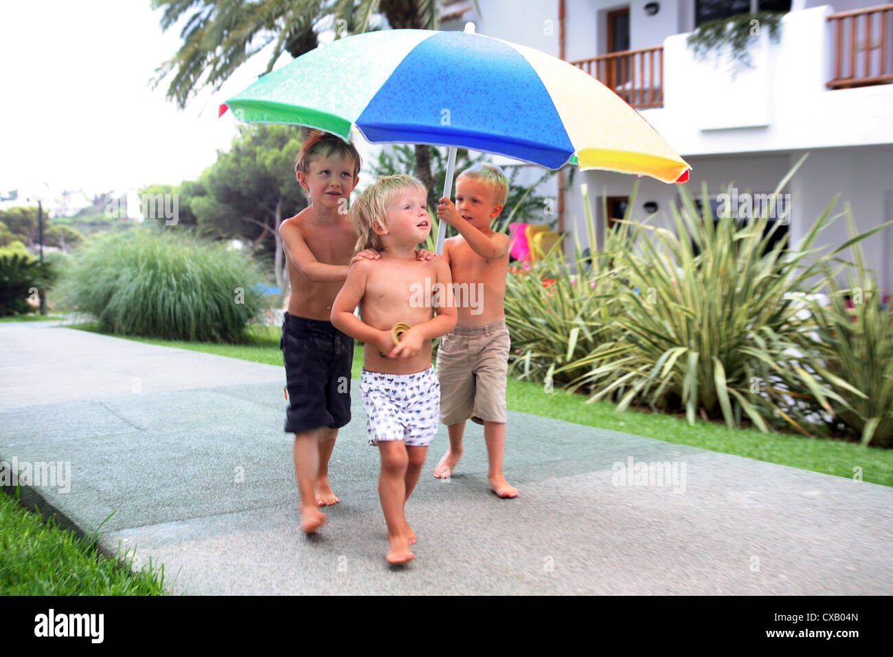 Valldemossa, les enfants courir sous la pluie sous un parapluie Photo Stock  - Alamy