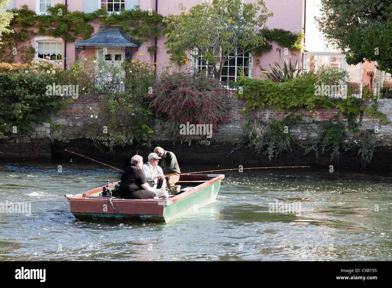 Trois hommes dans un bateau de pêche sur la rivière Avon à Christchurch Dorset England UK. Banque D'Images