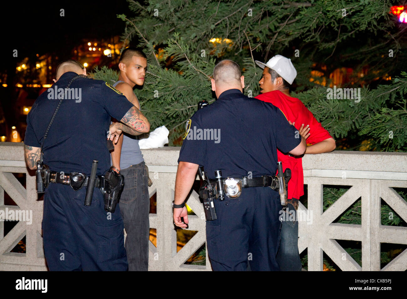 La police arrête des suspects le long de la rivière à pied à San Antonio, Texas, USA. Banque D'Images