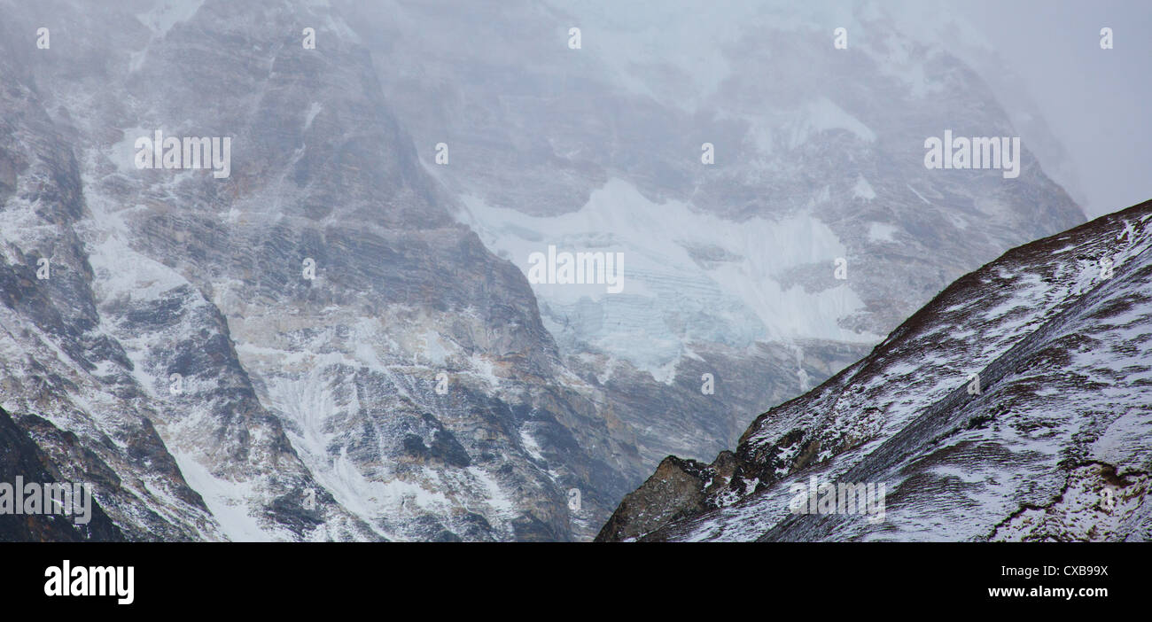 La brume et le brouillard sur le flanc d'une montagne couverte de neige, Langtang, Népal Banque D'Images