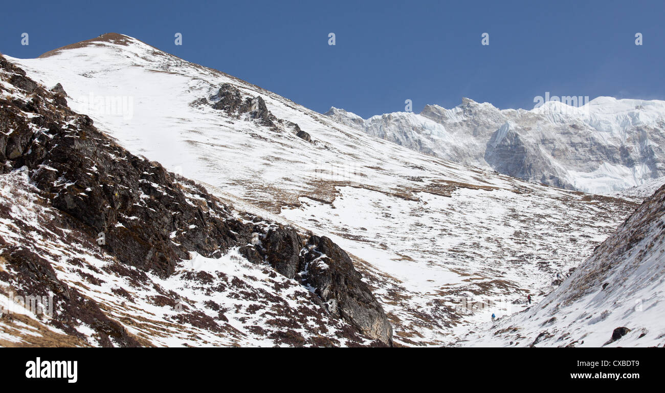 Les gens de la randonnée vers le haut du côté d'une montagne couverte de neige, Langtang, Népal Banque D'Images