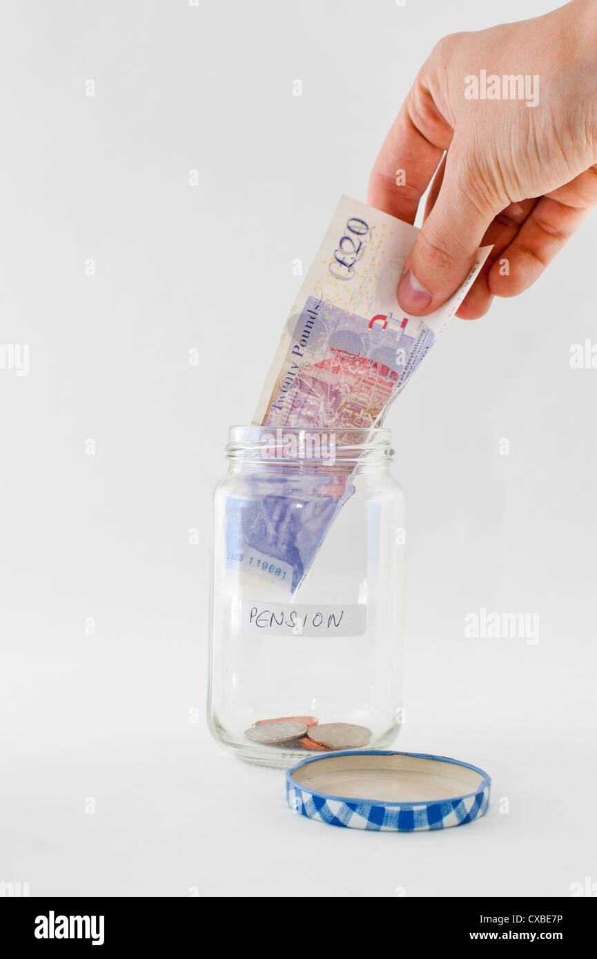 Une part de l'ajout d'un £20 pound note dans un bocal en verre avec de l'argent 'pension' étiquette. Banque D'Images