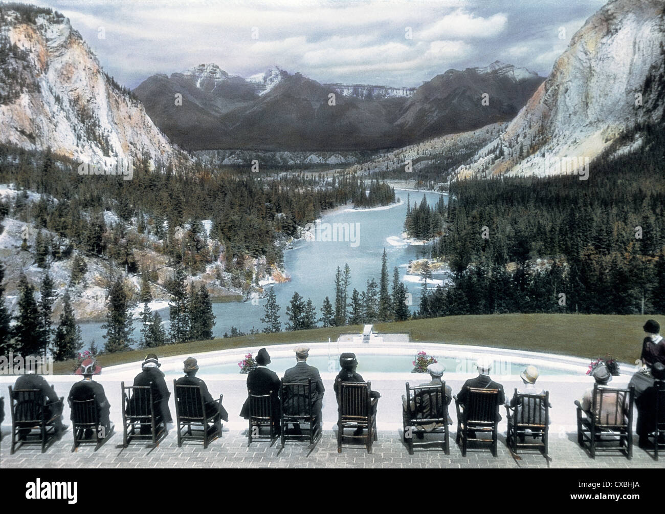 Photo colorée des touristes assis sur une terrasse qui surplombe une piscine et une vue panoramique sur la vallée de la rivière Bow, Banff Springs Hotel, Banff, Canada, 1916. (Photo de Burton Holmes) Banque D'Images