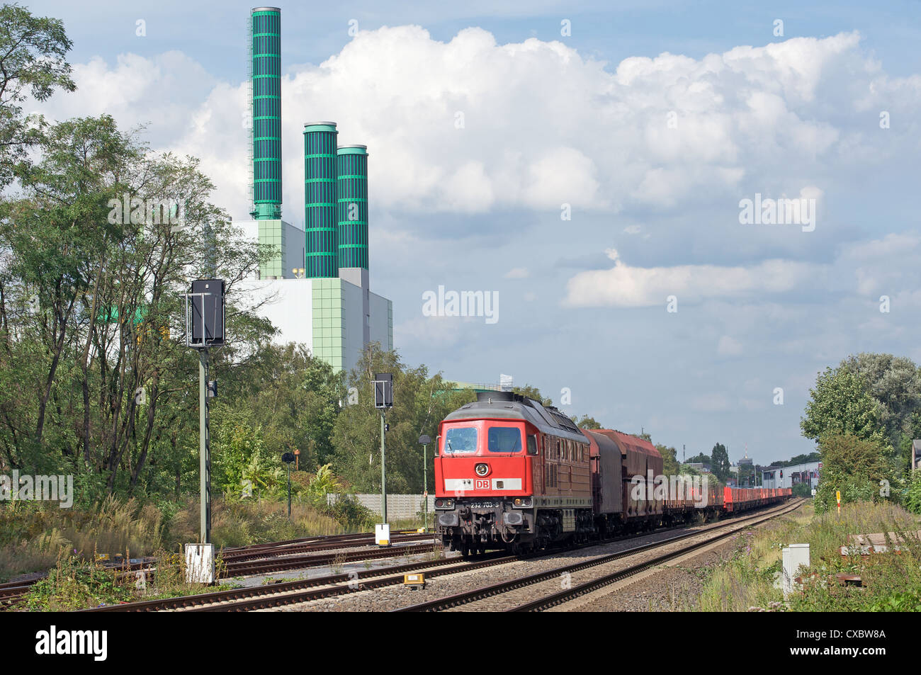 Train de fret passant une centrale électrique au gaz Banque D'Images