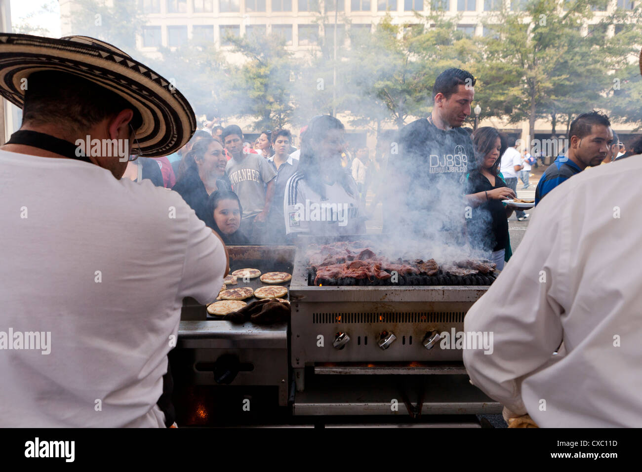 La cuisson sur le gril barbecue les hommes à un festival en plein air Banque D'Images