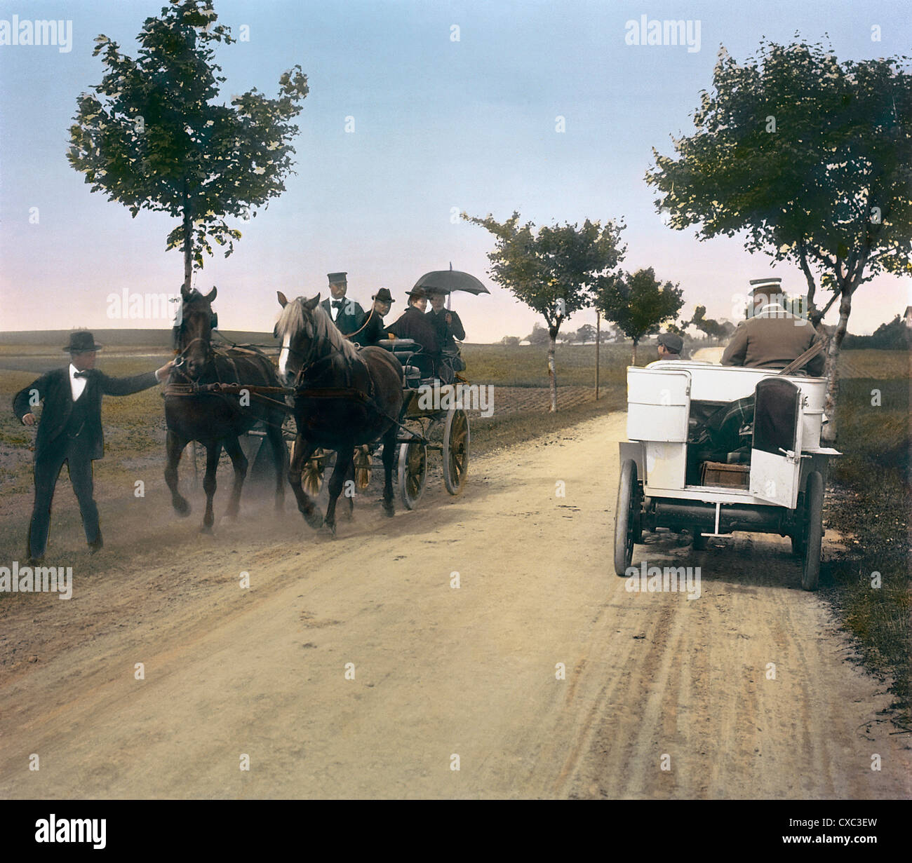 Photo colorisée des passagers dans un chariot tiré par un cheval qui a l'air choqué lorsqu'ils passent par une voiture sur une route de terre au sud de Copenhague, Danemark, 1902. Il y avait peu de voitures au Danemark au début des années 1900. (Photo de Burton Holmes) Banque D'Images