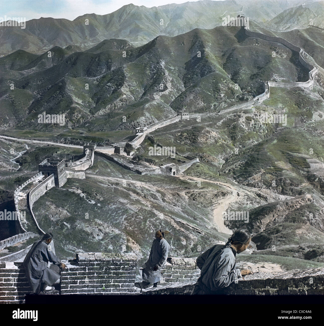 Vue en grand angle colorée des hommes regardant la terre en dessous de la Grande Muraille de Chine à l'un des nombreux cols de montagne, Chine, 1901. (Photo de Burton Holmes) Banque D'Images