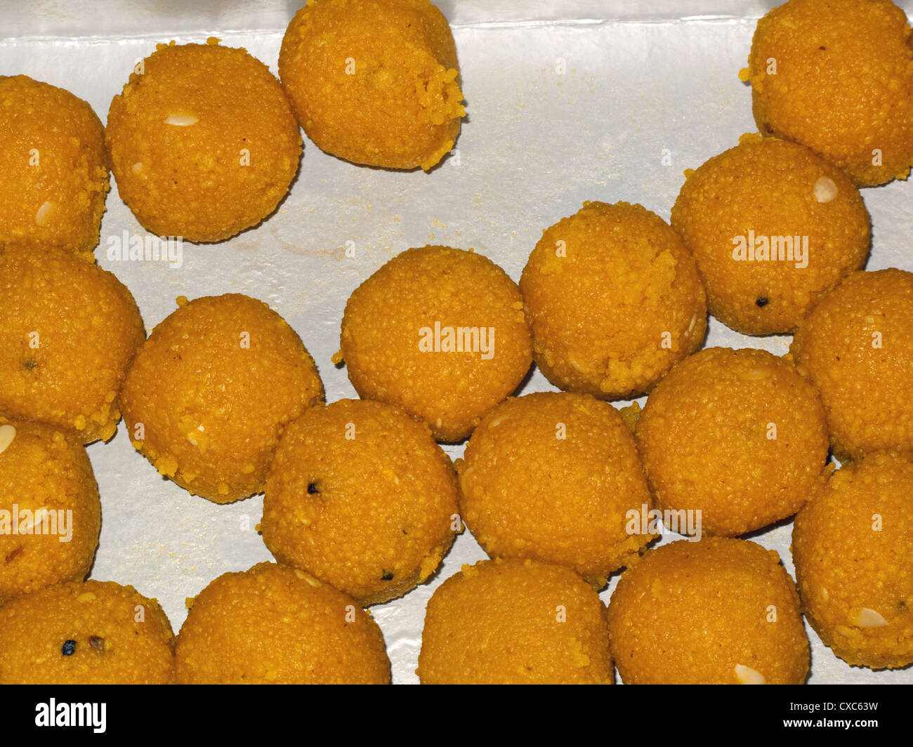 Très savoureux bonbons indiens (appelés Ladoos) faite en forme de boules ou sphères et conservés dans une boîte en carton Banque D'Images