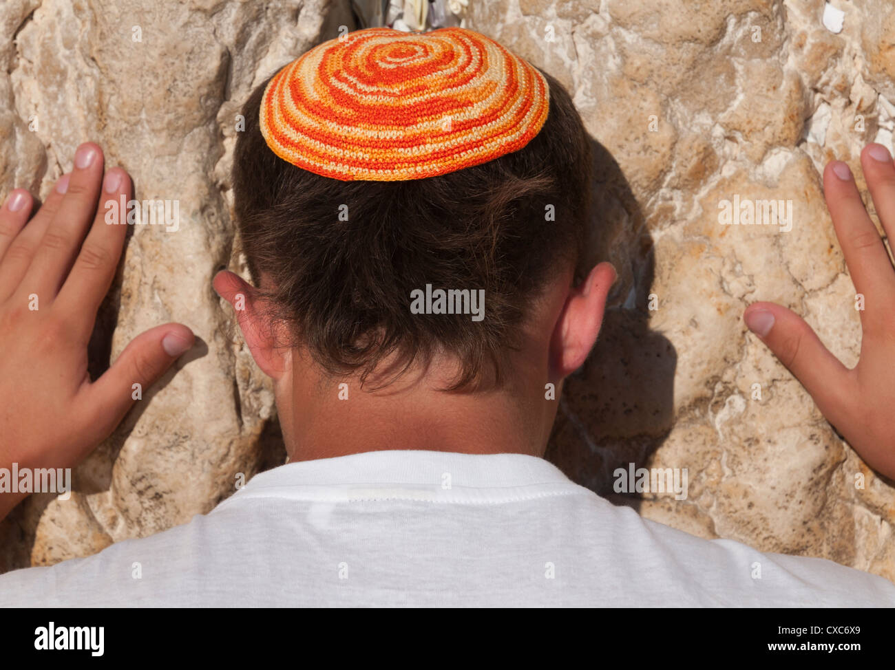 Close up of young man with bright yarmulka priant au Mur occidental, vieille ville, Jérusalem, Israël, Moyen Orient Banque D'Images
