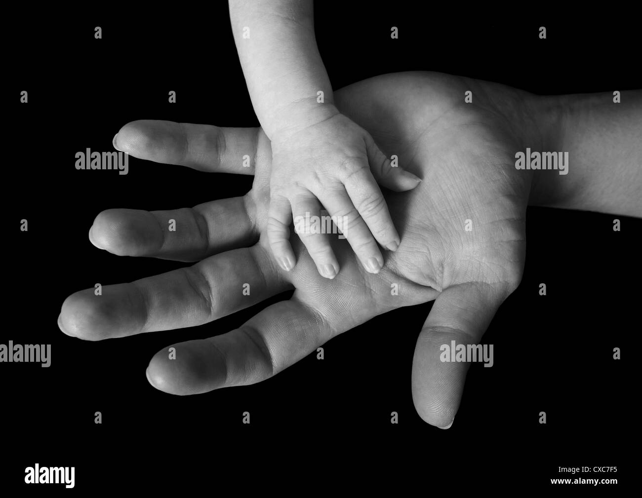 Jeune bébé reposant sa petite main sur sa mère. Banque D'Images