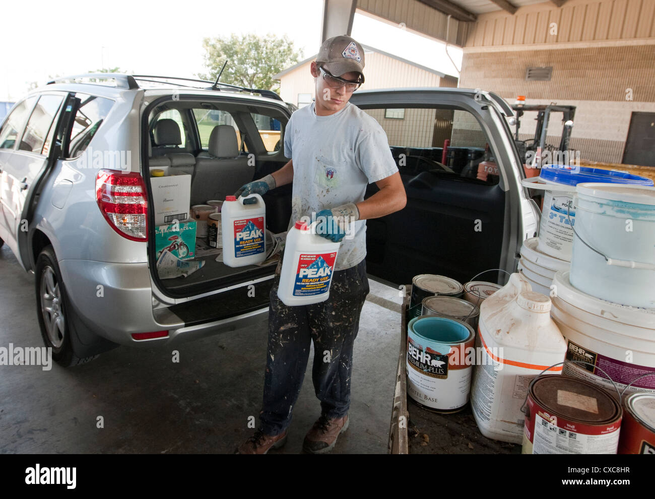 Employé à la ville de Austin de décharge de déchets ménagers dangereux de la peinture pour éliminer correctement les résidents Banque D'Images