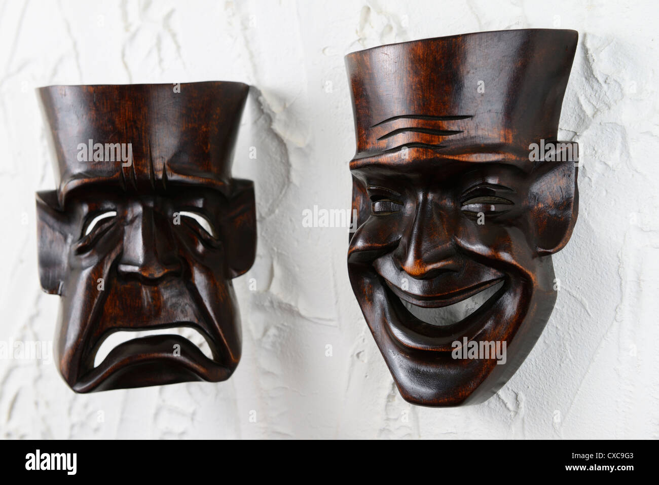 Heureux comedy theatre mask sur mur de plâtre avec masque tragique dans l'arrière-plan Banque D'Images